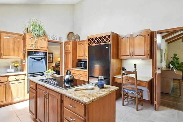 kitchen with high vaulted ceiling, a center island, light tile patterned floors, tasteful backsplash, and black appliances