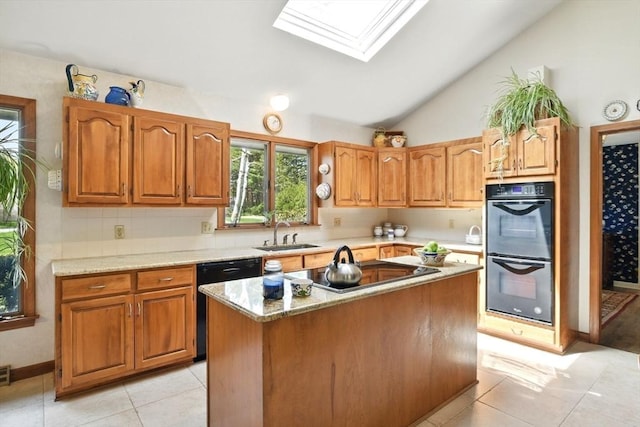 kitchen with brown cabinets, light tile patterned floors, a sink, and black appliances