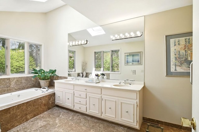 bathroom with double vanity, a sink, lofted ceiling with skylight, and a bath