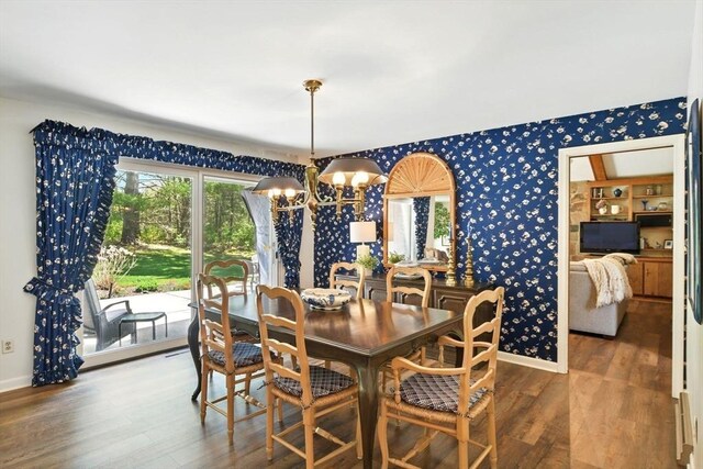 dining area with baseboards, wood finished floors, a chandelier, and wallpapered walls