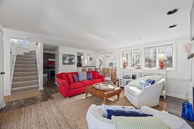 living area featuring baseboards, stairway, and wood finished floors