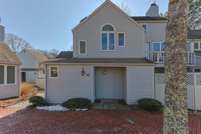 view of front of home with a chimney and fence