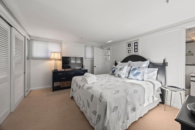 bedroom featuring light carpet, baseboards, and a closet