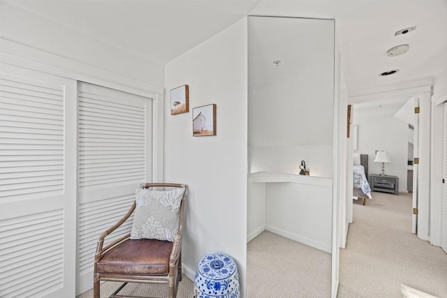 living area featuring light carpet and baseboards