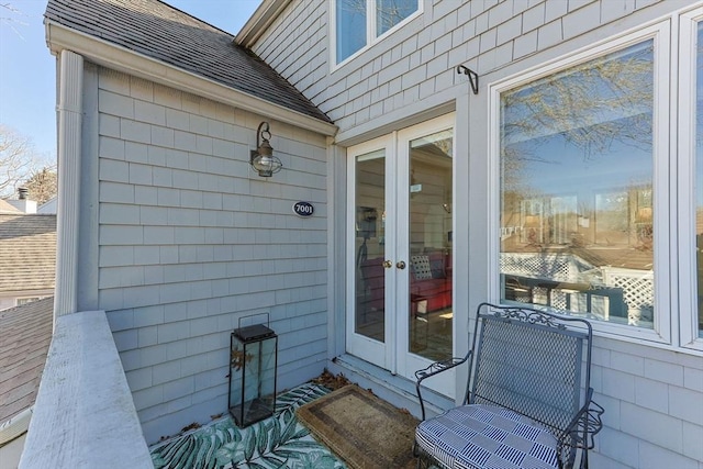 exterior space featuring roof with shingles and french doors