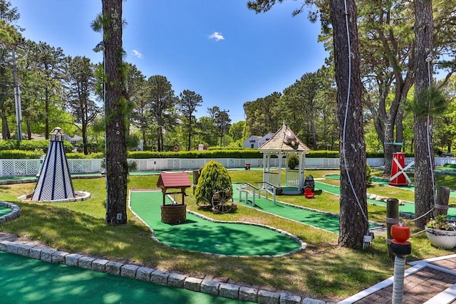 view of home's community featuring a yard, fence, playground community, and a gazebo