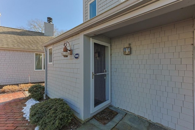 entrance to property with roof with shingles