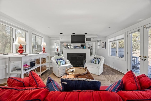 living area with a fireplace, wood finished floors, and baseboards