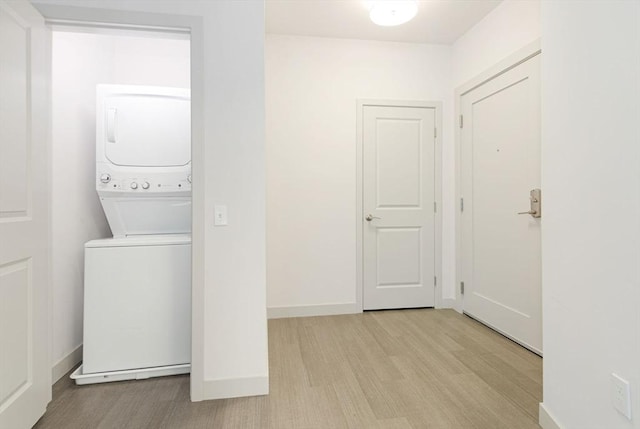 washroom with light wood-type flooring and stacked washer and dryer