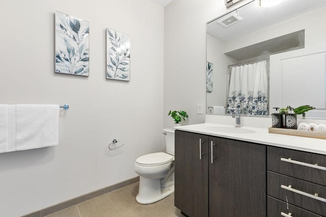 bathroom with tile patterned floors, vanity, toilet, and walk in shower