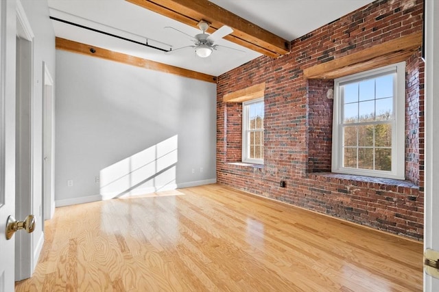 unfurnished living room featuring ceiling fan, brick wall, light hardwood / wood-style floors, and beamed ceiling