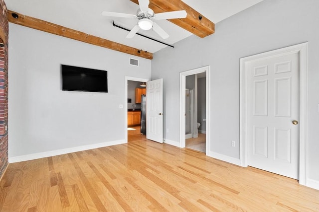 unfurnished bedroom featuring ensuite bathroom, hardwood / wood-style floors, ceiling fan, stainless steel refrigerator, and beam ceiling