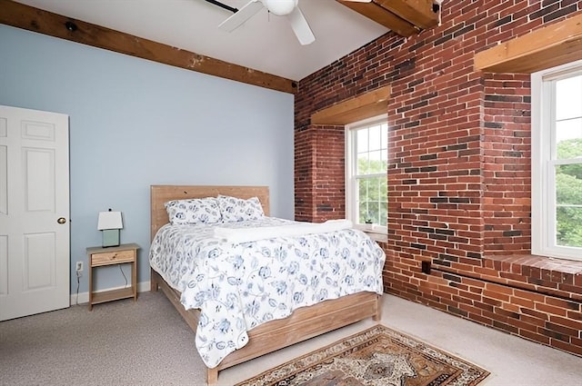 carpeted bedroom featuring ceiling fan, brick wall, and beamed ceiling