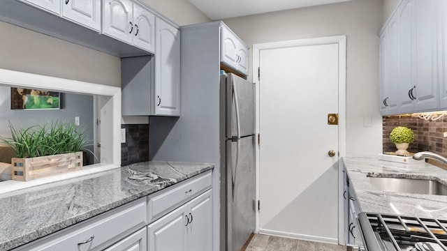 9 Longwood Dr Unit 11, Andover, MA 01810 - kitchen featuring backsplash, light stone countertops, white cabinetry, range, and freestanding refrigerator