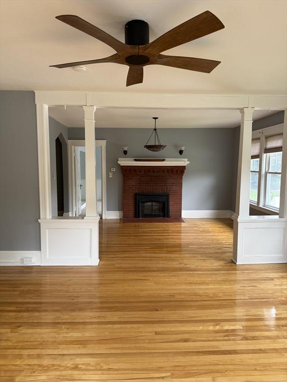 612 Grove St Lot 1, Worcester, MA 01605 - unfurnished living room with light wood-style flooring, decorative columns, a ceiling fan, and a fireplace