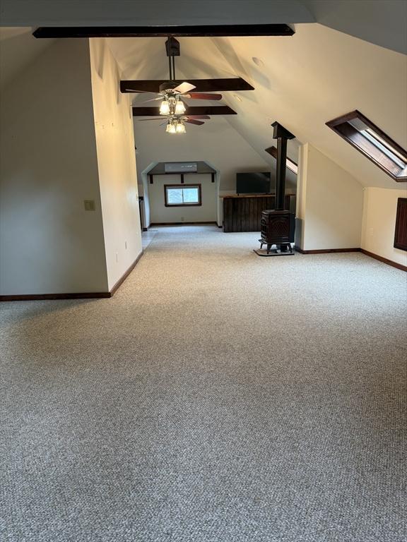 612 Grove St Lot 1, Worcester, MA 01605 - bonus room with vaulted ceiling, carpet, a wood stove, ceiling fan, and baseboards