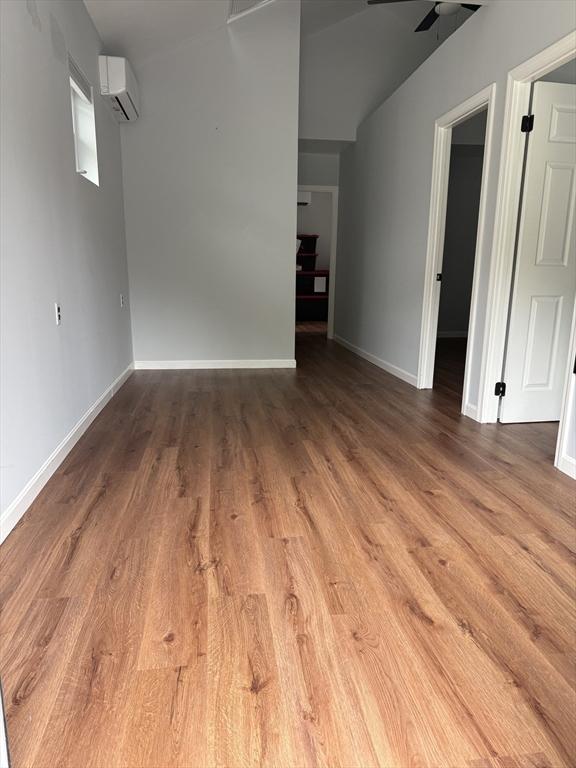 612 Grove St Lot 1, Worcester, MA 01605 - empty room with a wall unit AC, wood finished floors, baseboards, and a ceiling fan
