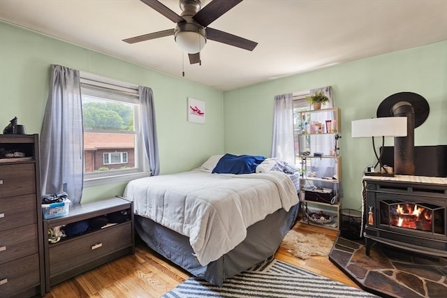96 Hurd St, Lynn, MA 01905 - bedroom with a wood stove, wood finished floors, and ceiling fan