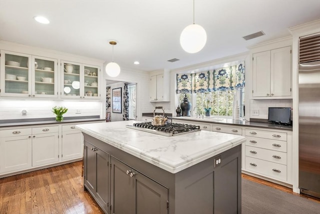 kitchen with visible vents, white cabinets, light wood-style floors, appliances with stainless steel finishes, and pendant lighting