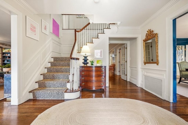 stairway featuring a decorative wall, wood finished floors, and ornamental molding