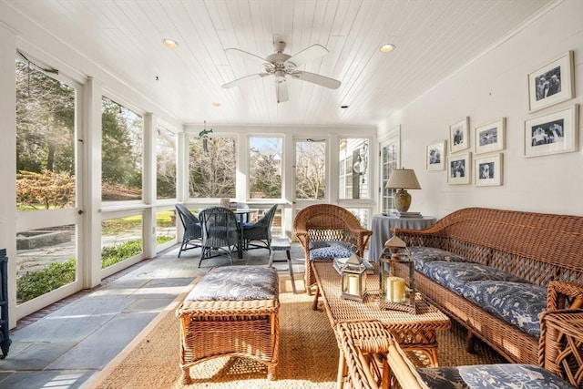 sunroom featuring wood ceiling and a ceiling fan