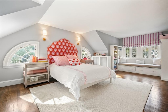 bedroom featuring multiple windows, baseboards, lofted ceiling, and hardwood / wood-style floors