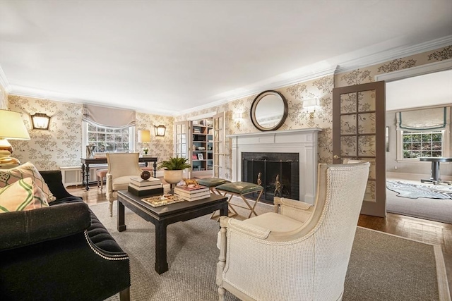 living room with wallpapered walls, crown molding, wood finished floors, and a wealth of natural light