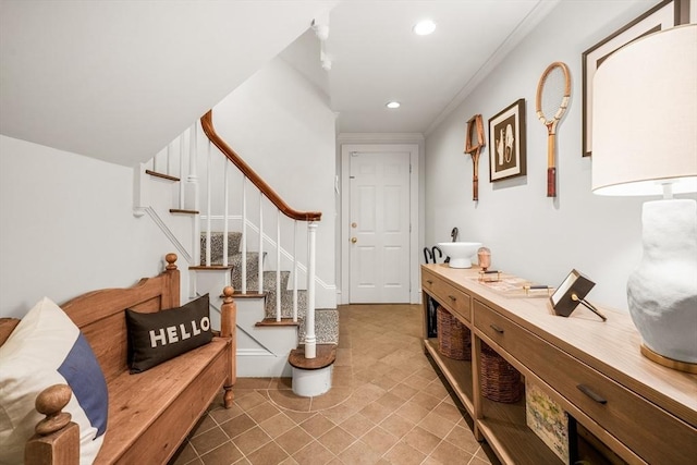 entryway with recessed lighting, ornamental molding, and stairs