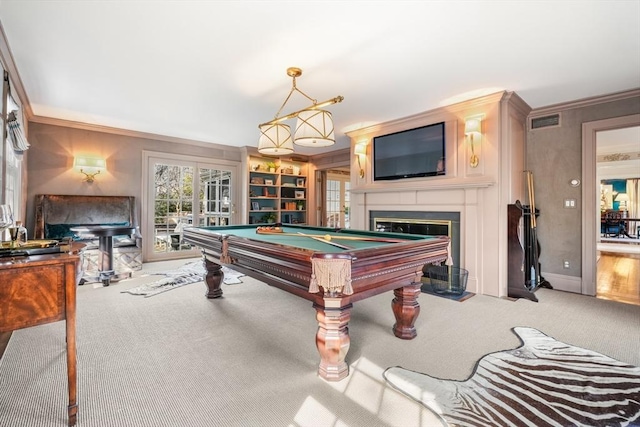 rec room featuring a fireplace with flush hearth, crown molding, visible vents, and carpet floors