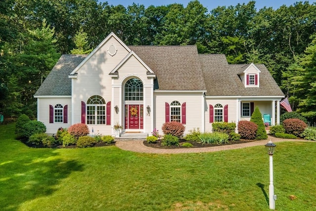 view of front of house featuring a front lawn and roof with shingles