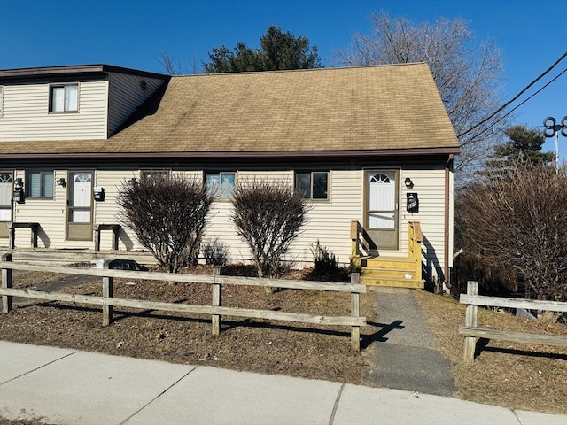 view of front of home with fence, a shingled roof, and entry steps