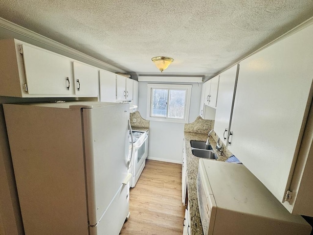 kitchen with a sink, a textured ceiling, white cabinetry, white appliances, and light wood-style floors