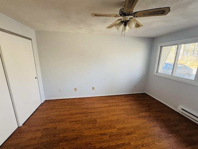 unfurnished room featuring a ceiling fan, wood finished floors, baseboards, a textured ceiling, and a baseboard heating unit