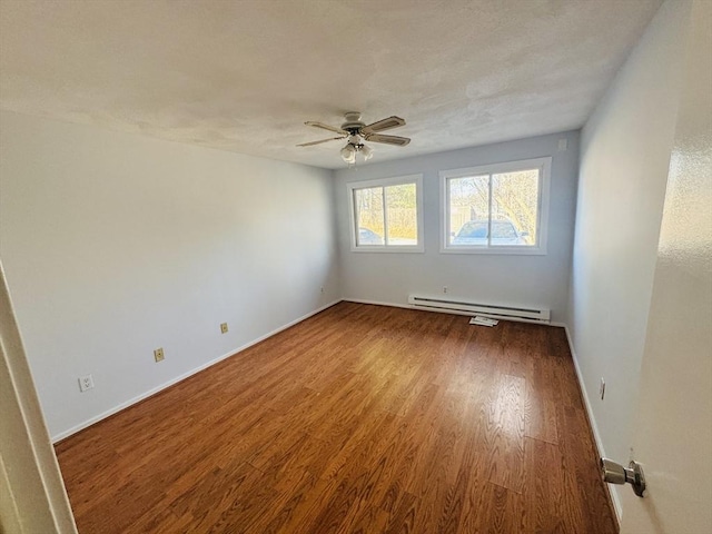 spare room with baseboards, ceiling fan, baseboard heating, wood finished floors, and a textured ceiling