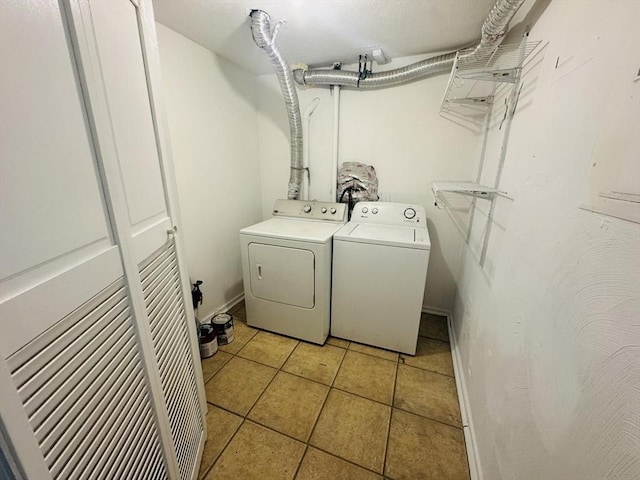 clothes washing area featuring light tile patterned flooring, laundry area, and washing machine and clothes dryer