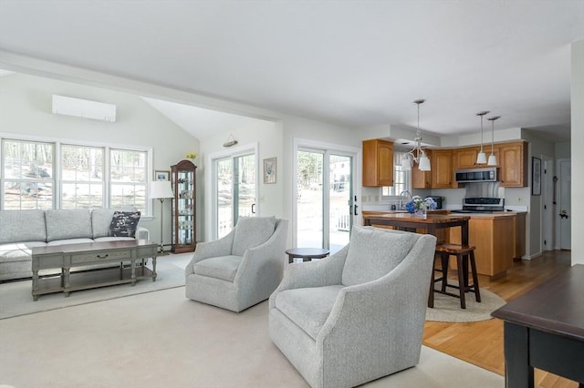 living area with a wall unit AC, light wood-style floors, and lofted ceiling