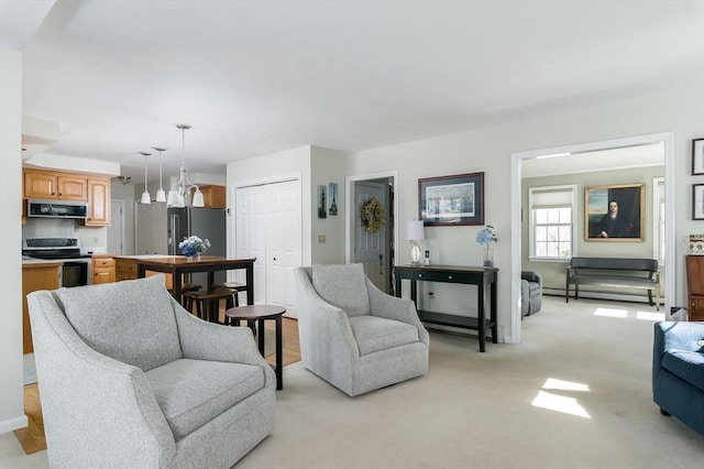 living area with baseboard heating and light colored carpet