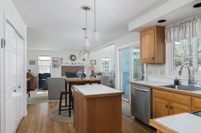 kitchen featuring dark wood-style flooring, a sink, open floor plan, stainless steel dishwasher, and a center island