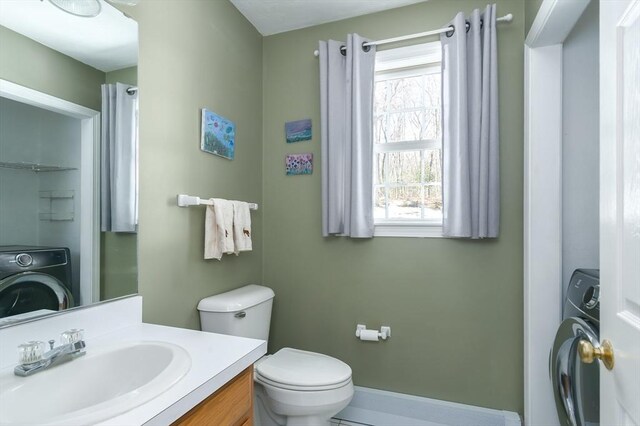 bathroom with toilet, washer / dryer, and vanity