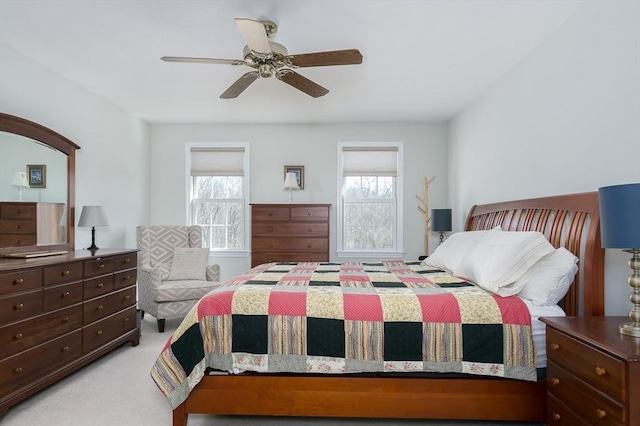 carpeted bedroom featuring multiple windows and ceiling fan