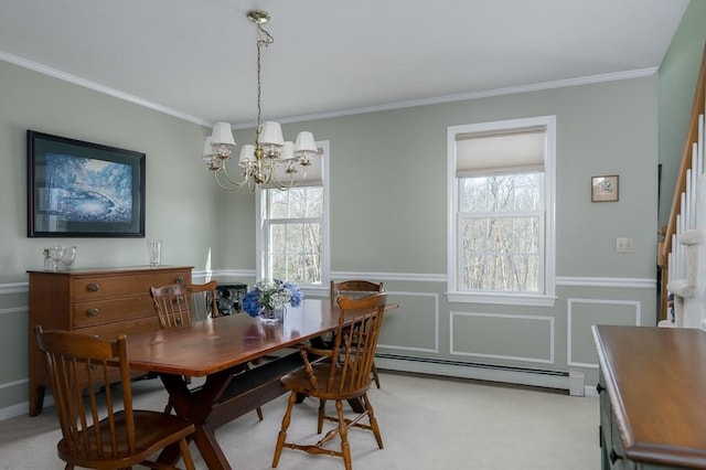 dining room featuring a baseboard heating unit, ornamental molding, wainscoting, and a chandelier