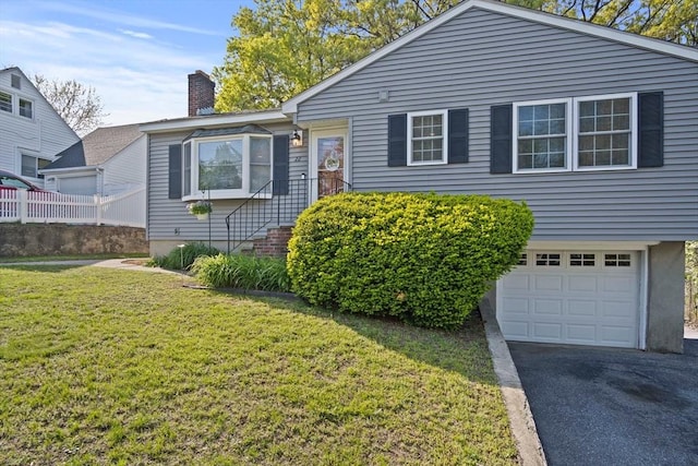 view of front of home with a garage, a front yard, asphalt driveway, and a chimney
