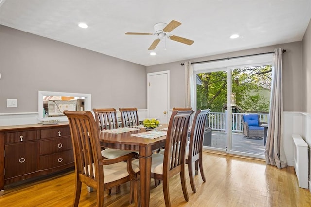 dining room featuring radiator, light wood-style flooring, a wainscoted wall, ceiling fan, and recessed lighting