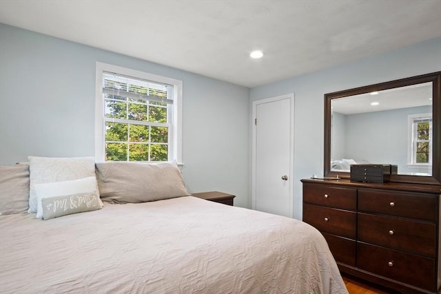 bedroom with multiple windows, recessed lighting, and wood finished floors