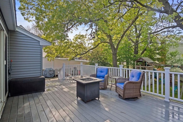 deck with a fire pit and a playground