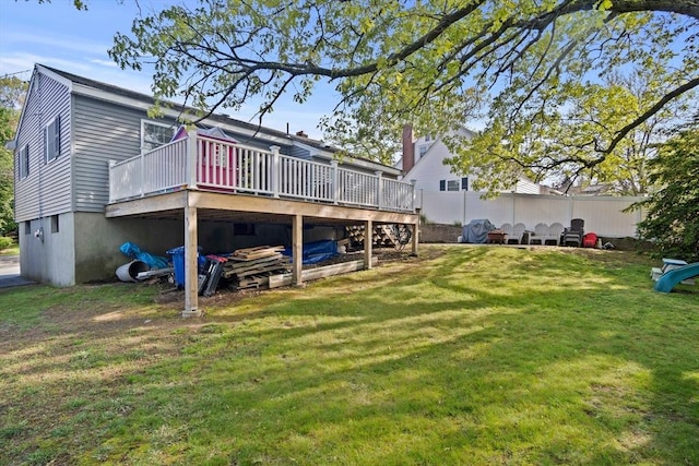 rear view of property with a yard and a wooden deck