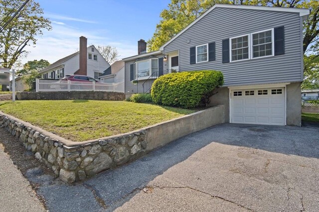 view of front facade featuring a garage, driveway, and a front lawn