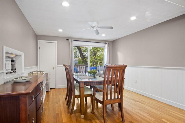 dining space with wainscoting, light wood-style flooring, a ceiling fan, and recessed lighting