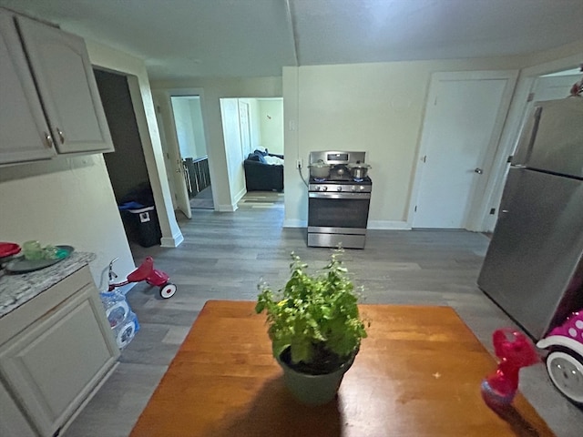 kitchen featuring light wood-type flooring, stainless steel appliances, white cabinetry, and butcher block countertops