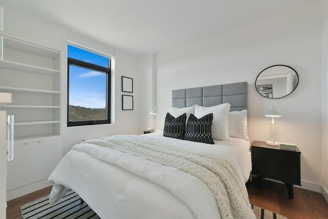 bedroom with baseboards and wood finished floors